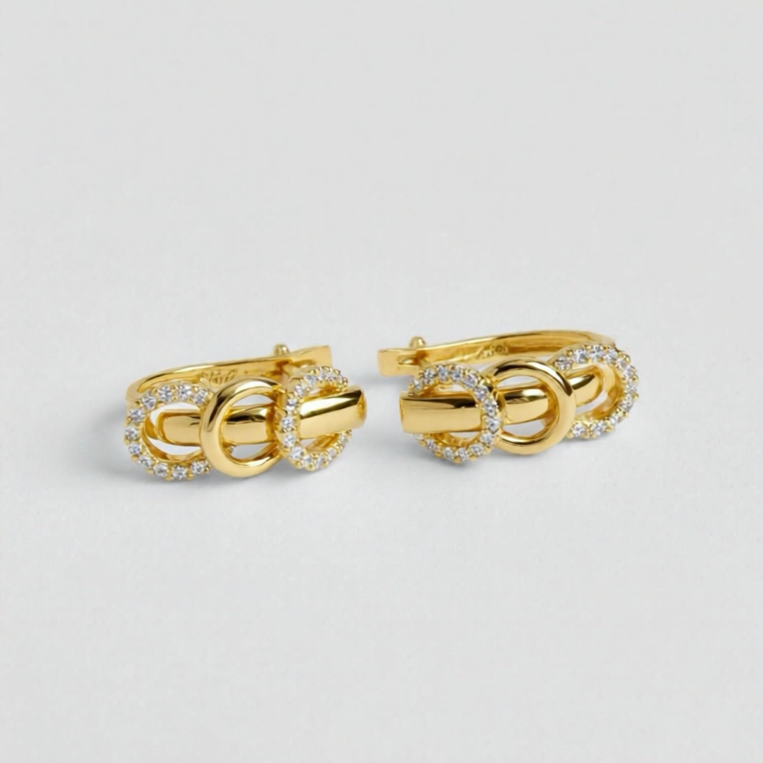 Pair of gold cufflinks with diamond accents on a light gray background
