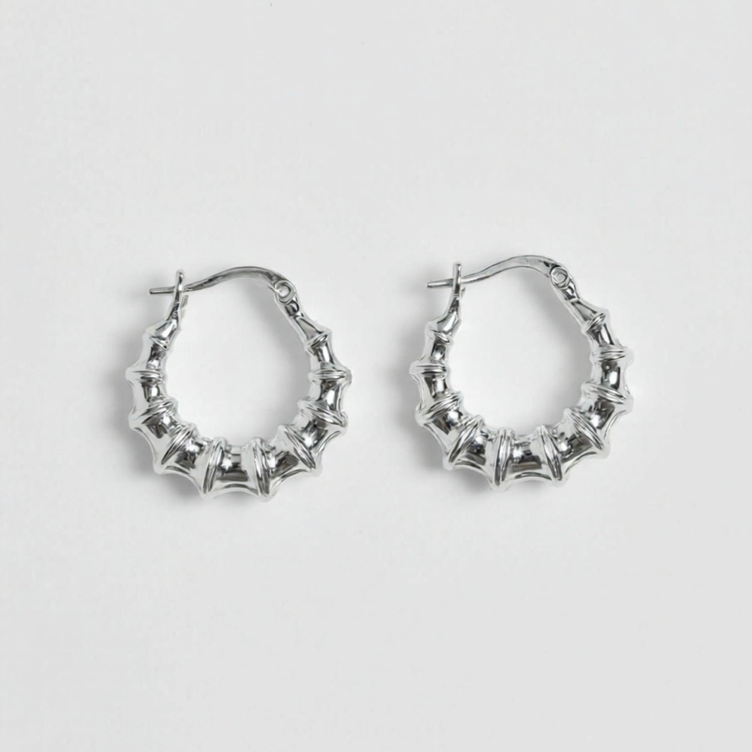 Silver hoop earrings on a light gray background