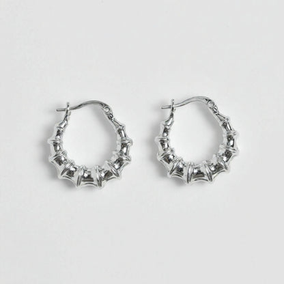 Silver hoop earrings on a light gray background