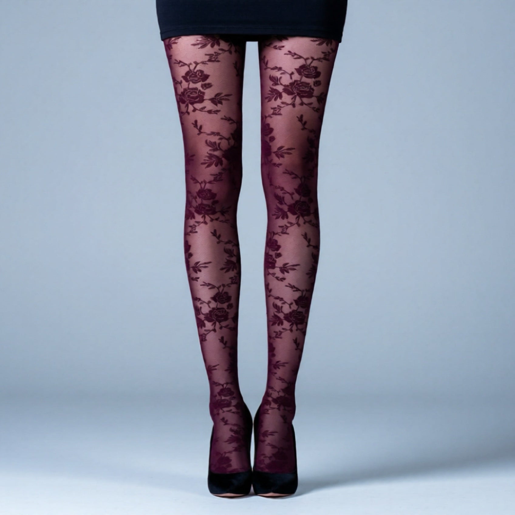 Dark floral-patterned tights worn by a person on a light blue background