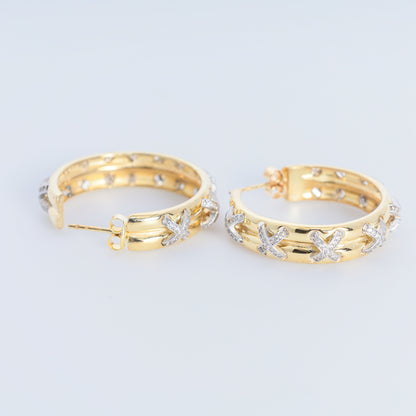 Gold hoop earrings with star designs on a light gray background