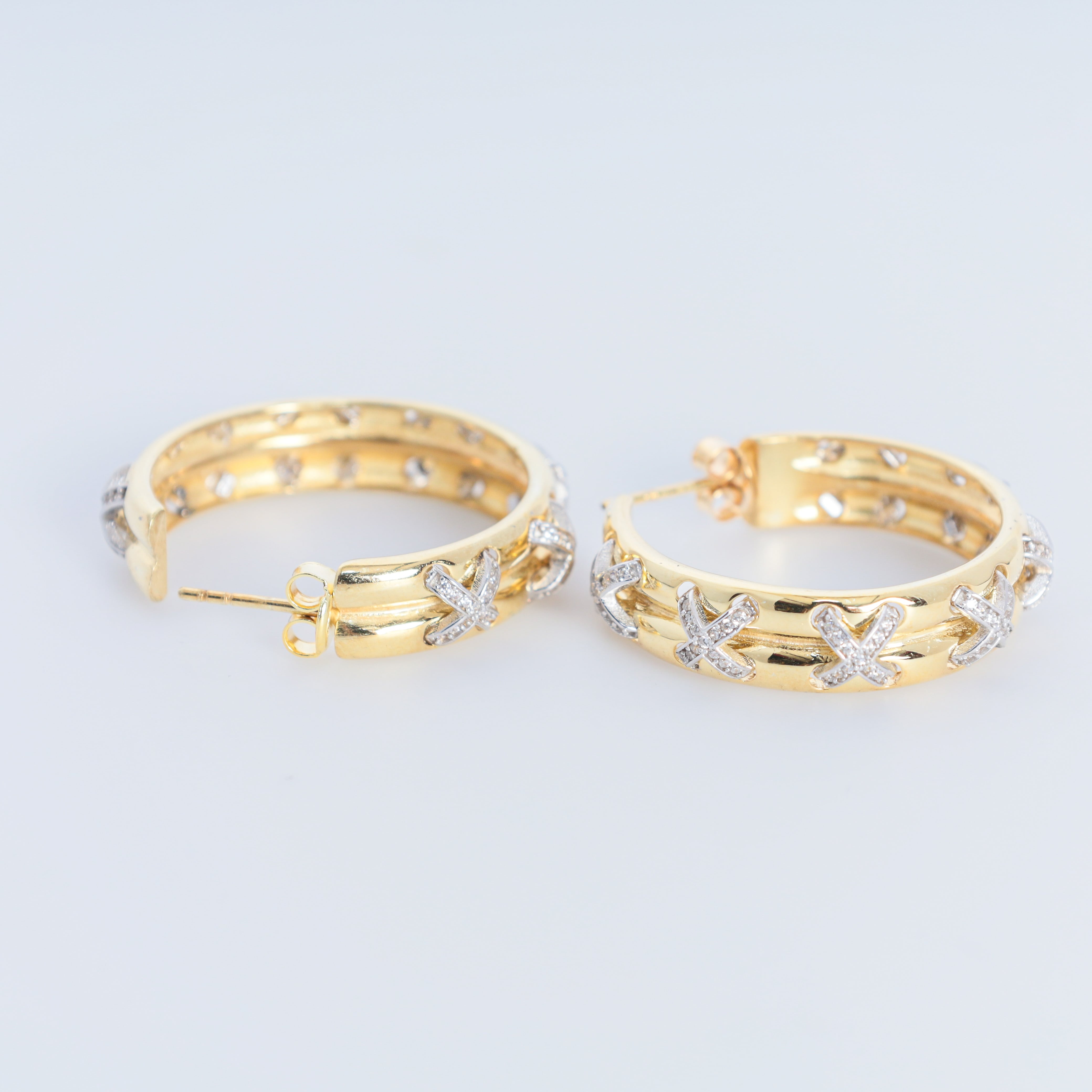 Gold hoop earrings with star designs on a light gray background