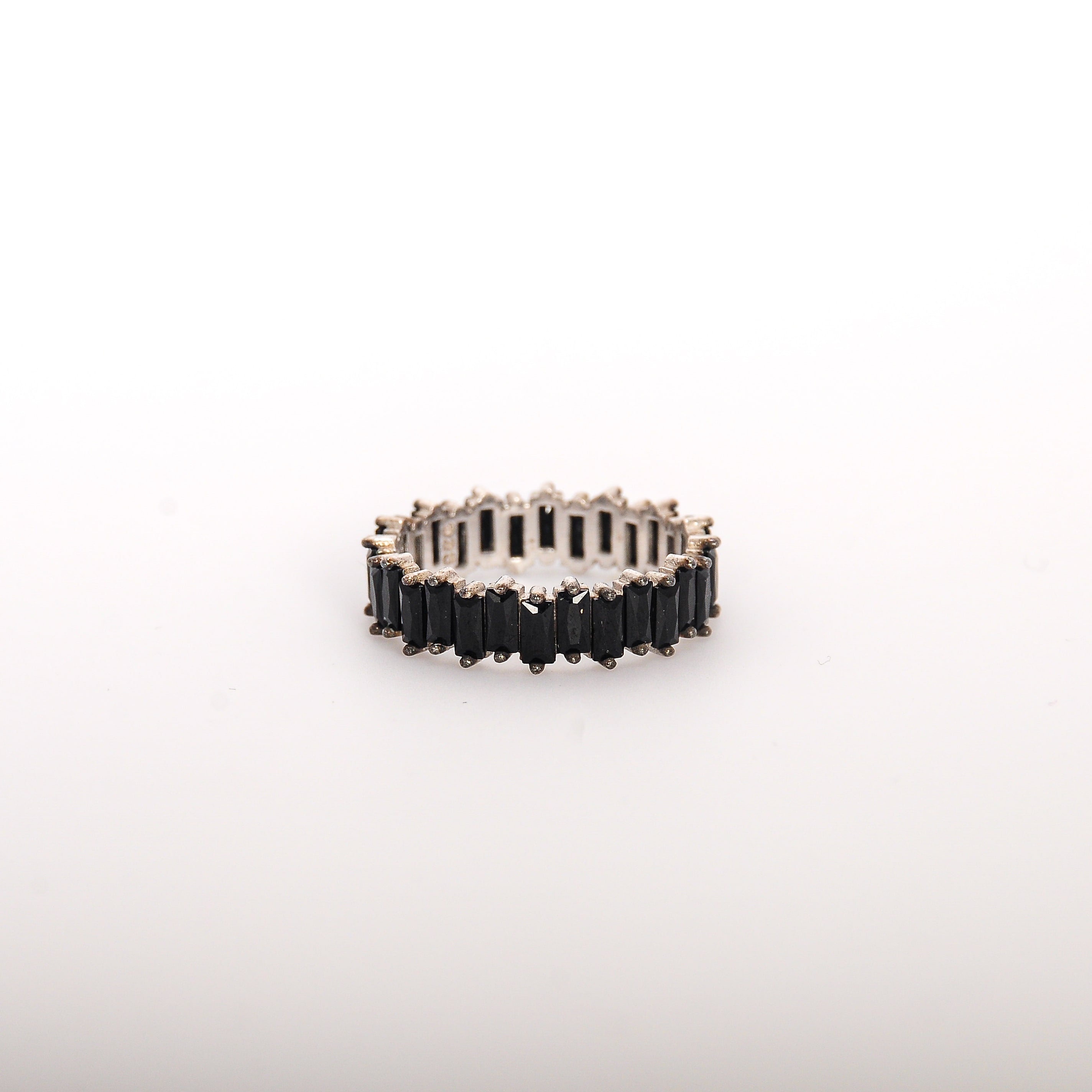 Silver ring with black stones on a white background