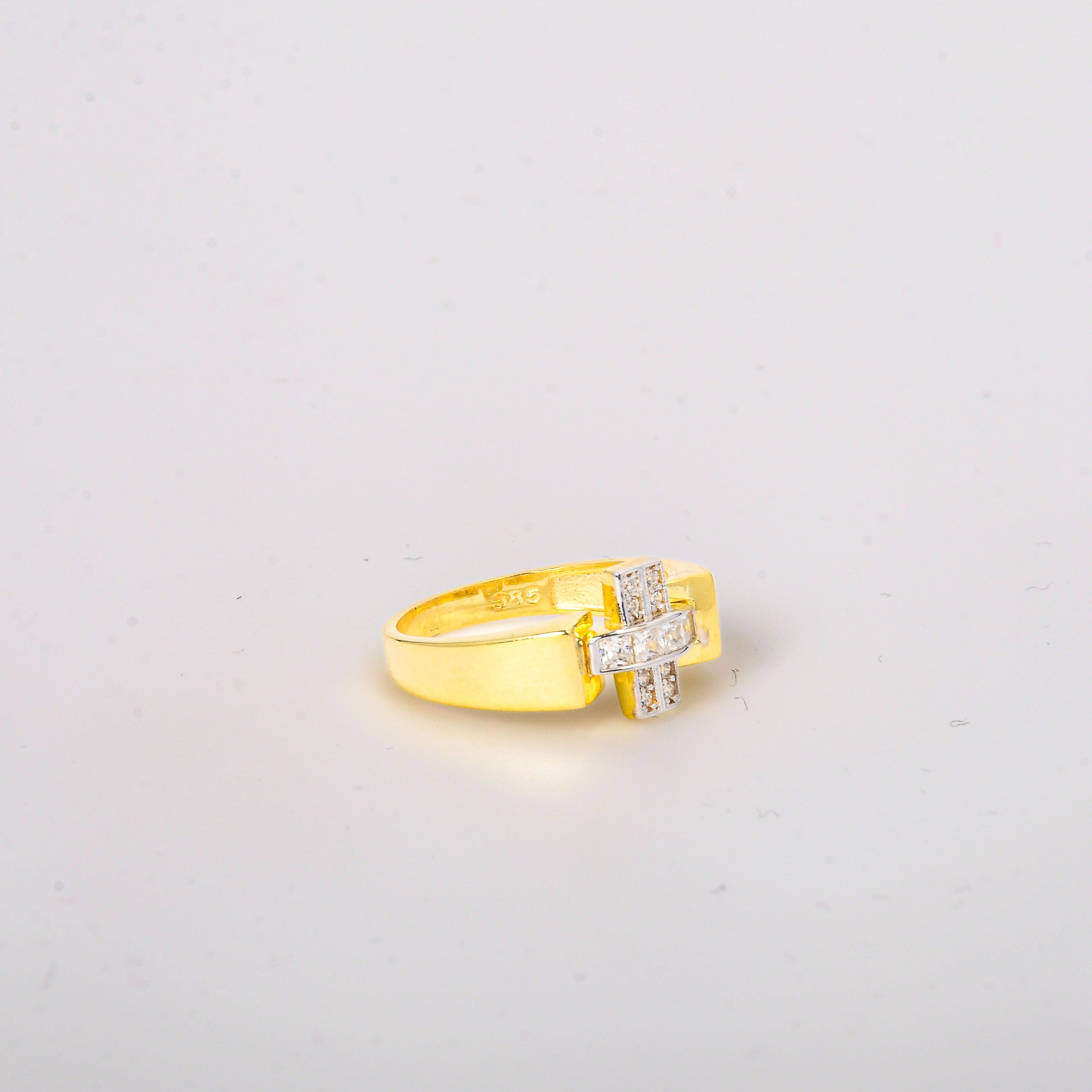 Gold ring with a diamond on a light gray background