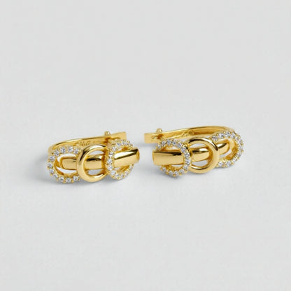 Pair of gold cufflinks with diamond accents on a light gray background