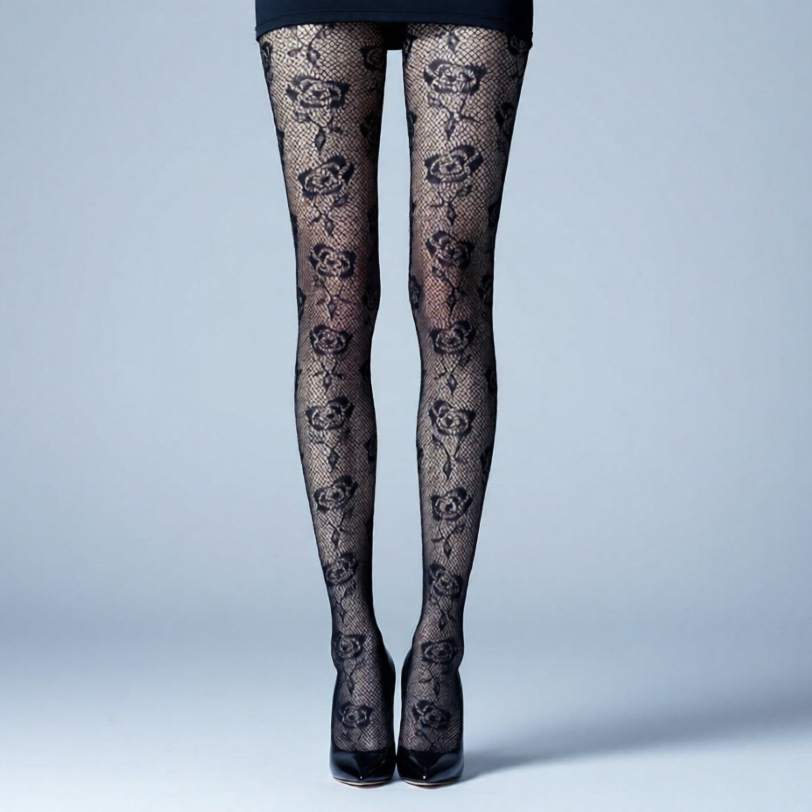 Black lace tights with floral patterns on a light gray background