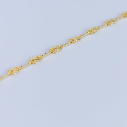 Gold bracelet in a black jewelry box with 'X Studio' branding on a light gray background