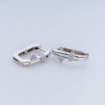 Pair of silver hoop earrings with small diamonds on a light gray background