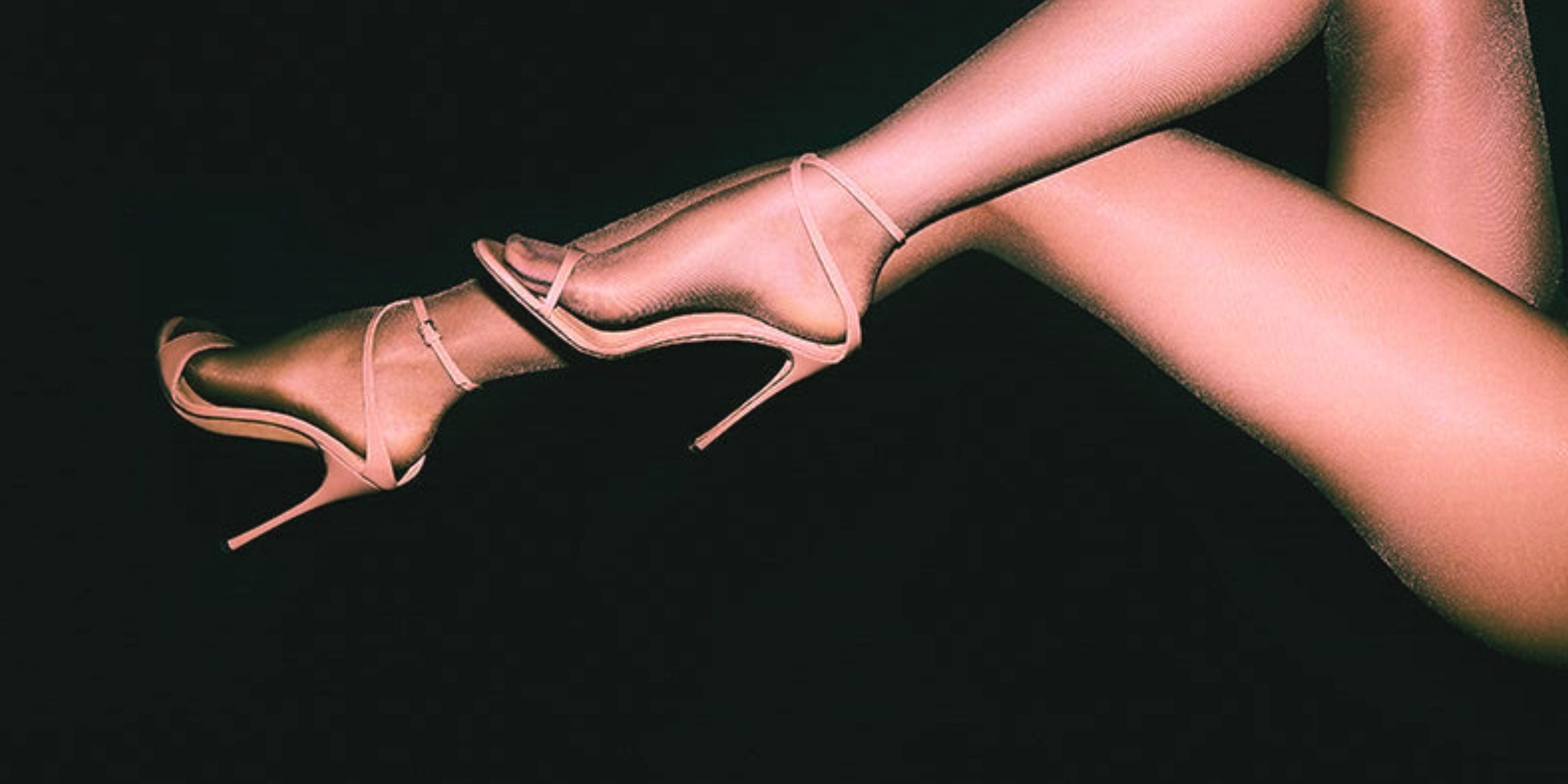 High-heeled shoes worn by a person against a black background
