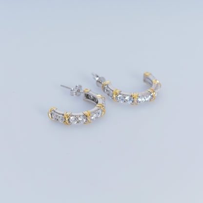 Gold and silver hoop earrings on a light gray background