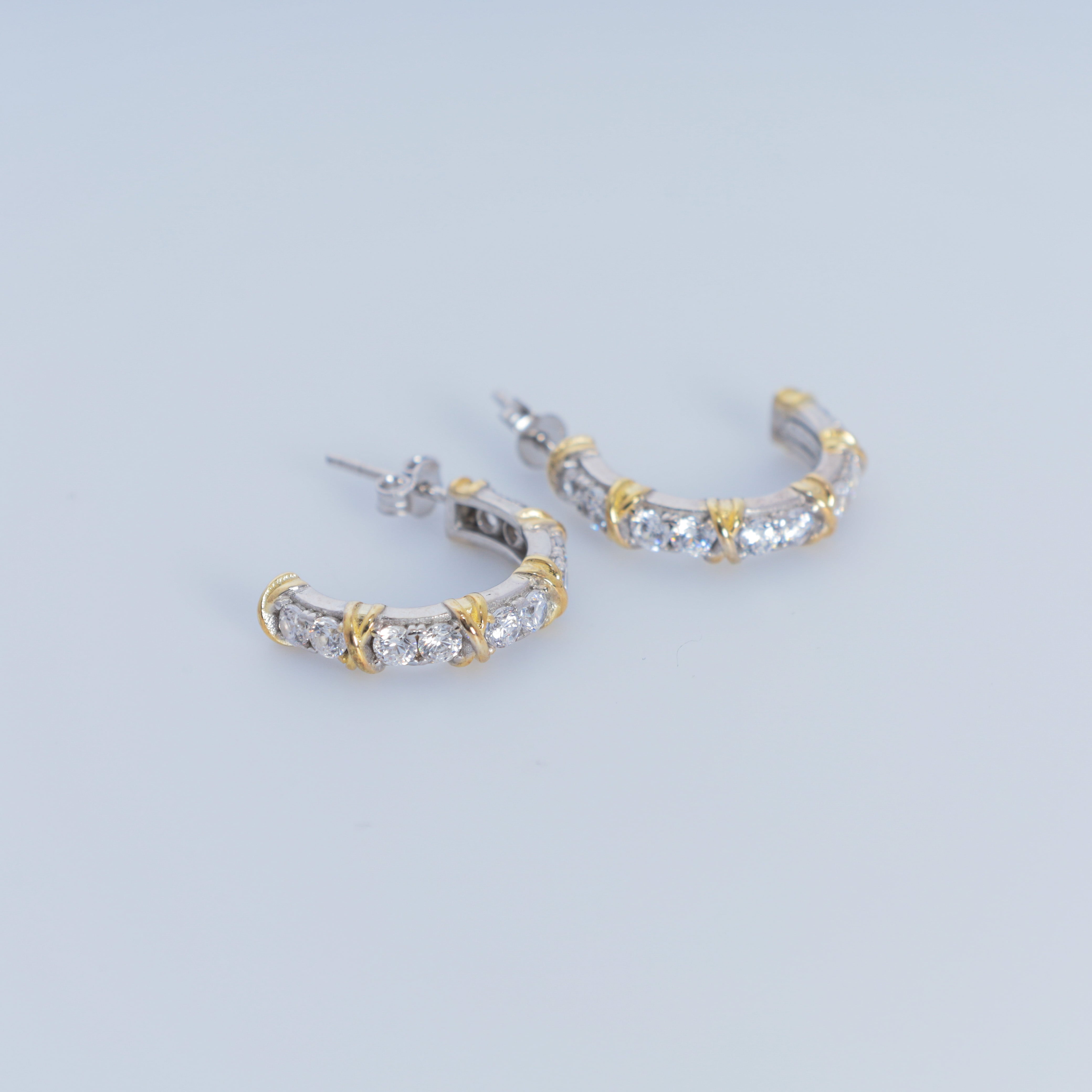 Gold and silver hoop earrings on a light gray background